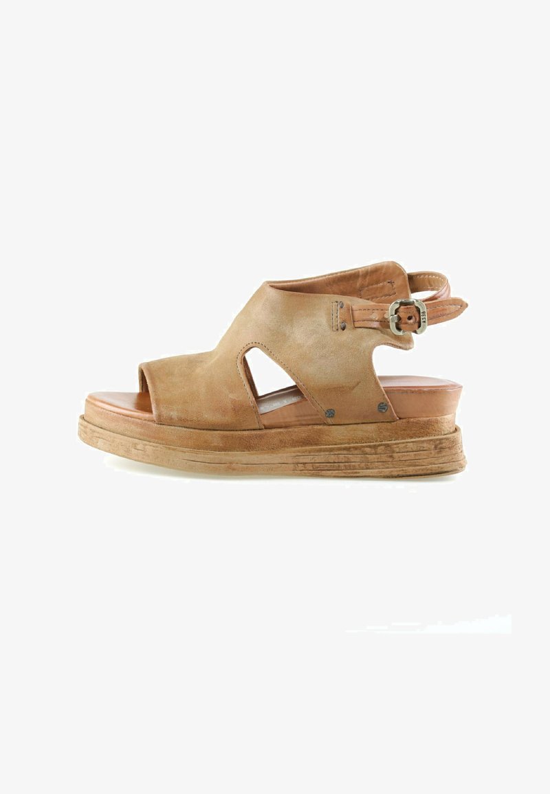 Sandale compensée en suède brun à bout ouvert avec découpes latérales, bride de cheville réglable et semelle texturée sur fond blanc.
