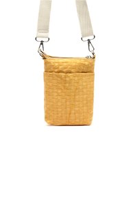 Texturovaná žlutá crossbody kabelka se zipovým uzávěrem, s tkaným vzorem a bledým nastavitelným popruhem. Viditelné dva oddíly.