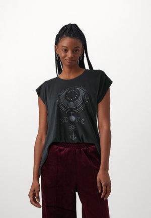 Zwarte katoenen T-shirt met korte mouwen en een ronde halslijn, voorzien van een witte grafische print van sterren op de voorkant. Gecombineerd met bordeauxrode broek.