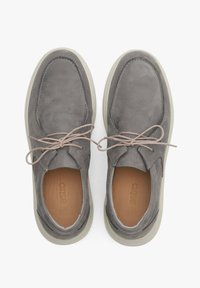 Chaussures en daim grises à bout arrondi, doublure en cuir et semelle en caoutchouc clair. Présentent des lacets neutres et un minimum de détails de couture.