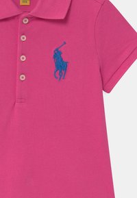 Růžové polokošile z texturované látky s tříknoflíkovým zapínáním a modrým vyšívaným logem koně na levé straně hrudi.