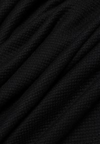 Schwarzer, strukturierter Stoff mit weicher, gewebter Struktur. Verfügt über subtile Muster und fällt sanft, was das flexible und warme Design unterstreicht.