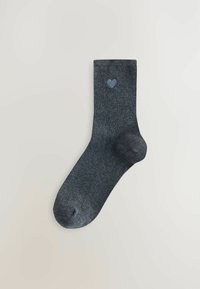 Mörkgrå ribbad strumpa med en ljusblå hjärtformad design nära toppen. Har en rundad tå och förstärkt häl. Mjuk textur.