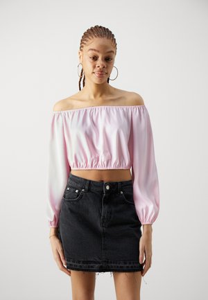 Off-the-shoulder, light pink satin top with a gathered hem, paired with a black denim mini skirt featuring a frayed hem and front pockets.