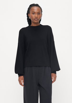 Pull en tricot noir avec une coupe décontractée, épaules tombantes et longues manches bouffantes. Texture lisse avec un col rond.