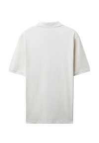 Polo a maniche corte in beige chiaro, con un tessuto testurizzato, colletto classico e spacco sui lati dell'orlo per una vestibilità rilassata.