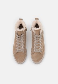 Béžové semišové vysoké tenisky s umělou kožešinou, plochými šedými tkaničkami, zadním poutkem a bočním zipem pro snadné obléknutí.