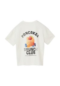 Witte t-shirt met korte mouwen, voorzien van een kleurrafiek van pannenkoeken, de tekst "Pancakes Brunch Club" en decoratieve vruchten in felle kleuren.