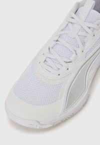 Hvide sportsko lavet af mesh- og syntetiske materialer, med en tekstureret finish og subtile detaljer, designet til præstation.