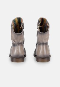 Botas de piel gris hasta el tobillo con detalles texturizados, acabado suave y forro de tela a rayas. Presentan un pequeño tacón y cierre de cremallera lateral.