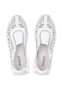 Bílé nazouvací boty s perforovaným květinovým vzorem a elastickými bočními akcenty, s texturovanou mezipodešví a hladkým vnitřním podšívkou.