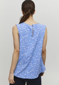 Blouse sans manches bleu clair avec un motif floral, texture douce, ourlet arrondi et un détail de bouton en forme de trou de serrure à l'arrière.