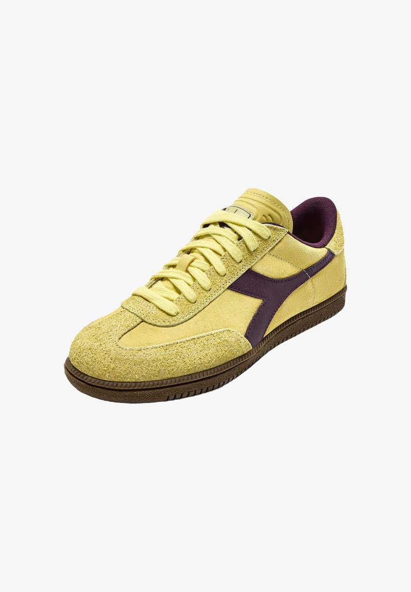 Sneaker in suede sintetico giallo con accenti viola, punta rotonda, stile con lacci piatti, tomaia testurizzata e suola in gomma marrone.