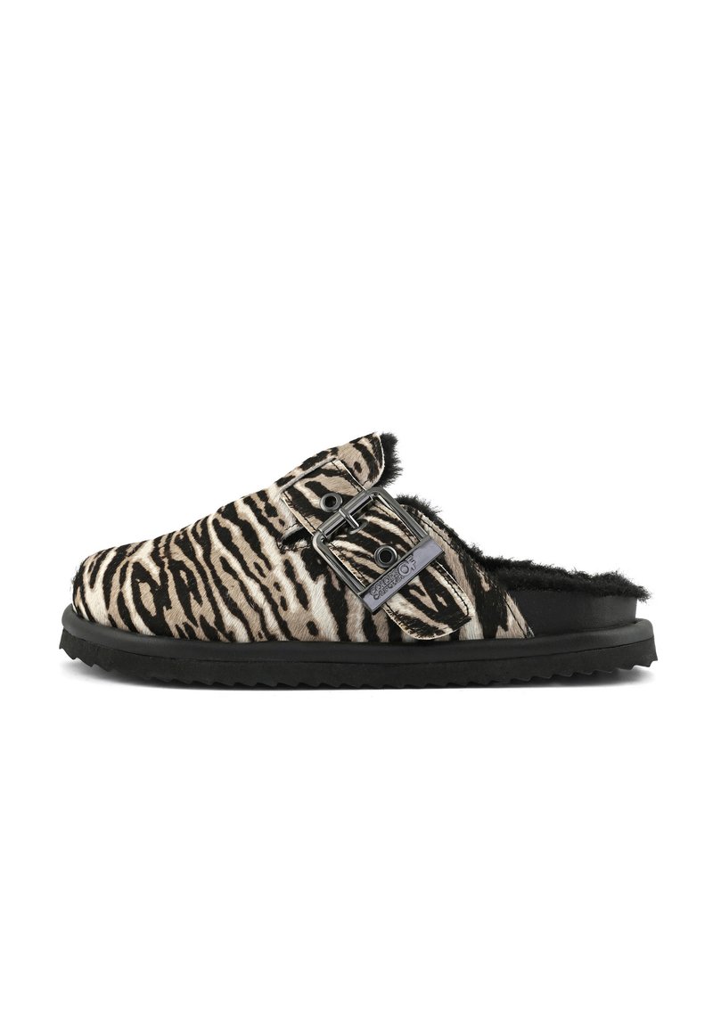 Chaussure slip-on avec un motif zèbre noir et blanc, grande boucle réglable et doublure en fausse fourrure noire sur une semelle noire.