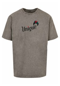 Grå kortærmet t-shirt lavet af bomuld med rund hals. Har ordet "Unique" i sort skrift samt blomsteraccenter ovenfor.