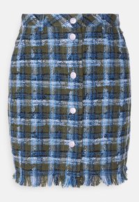 Falda a cuadros en verde, azul y blanco con dobladillo de flecos. Presenta seis botones morados y una tela texturizada. Largo por encima de la rodilla.