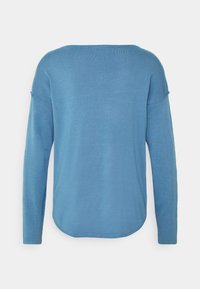 Niebieski sweter z długim rękawem o luźnym fasonie, z okrągłym dekoltem i opuszczonymi ramionami. Miękka faktura z gładkim wykończeniem i zaokrąglonym dołem.