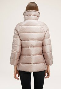 Jachetă puffer de culoare roz, cu guler înalt, având un model matlasat și mâneci de lungime medie. Textură netedă și lucioasă.