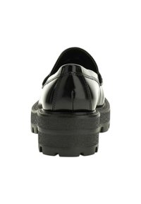 Mocassino in pelle nera lucida con suola in gomma spessa e texture, visto dal retro su uno sfondo bianco.