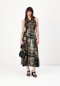 Rochie fără mâneci de culoare neagră și aurie, cu fustă evazată și textură metalică. Asortată cu o geantă neagră matlasată și sandale cu toc pătrat negre.