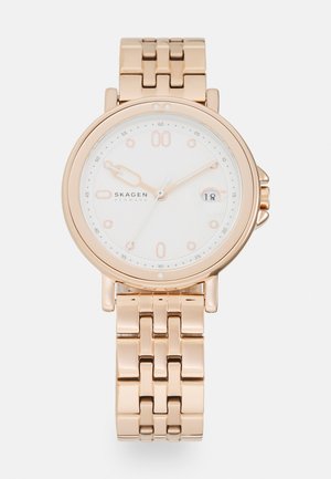 Roségoldfarbene Uhr mit rundem weißen Ziffernblatt, silbernen Indizes und Datumsanzeige. Verfügt über ein Link-Armband für einen sicheren Sitz. Minimalistisches Design.