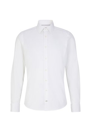 Camicia bianca a maniche lunghe con colletto classico, chiusura con bottoni e polsini a un bottone. Presenta una sottile trama e un corsetto decorativo sull'orlo.