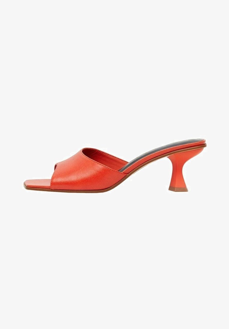 Mules à talons en cuir rouge avec un bout ouvert, présentant un design élégant et un talon bloc angulaire unique. Texture lisse avec un style minimaliste.