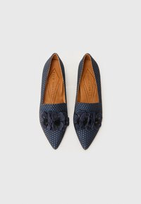 Ballerines pointues bleu marine avec un motif de pois texturé et des accents floraux sur le dessus, dotées d'une semelle en cuir marron.