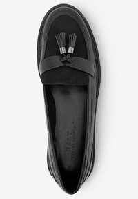 Schwarze Lederloafers mit einem Obermaterial aus Wildleder, ausgestattet mit einer geflochtenen Akzentuierung und Quasten, flacher Sohle und geprägtem Markennamen im Inneren.