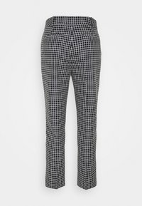 Czarno-białe spodnie o prostych nogawkach w kratę, pokazane od tyłu, z dwoma tylnymi kieszeniami i szlufkami na pasek.