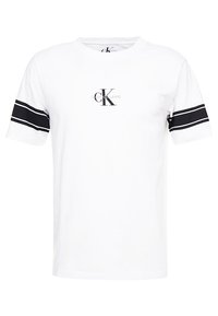 Valkoinen puuvillapaita lyhyillä hihoilla, jossa on mustat raidat hihoissa ja keskeinen printattu logo. Rentomallinen, sileä tekstuuri.