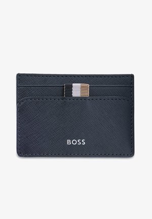 Navy leather card holder with textured surface, multiple slots, and a striped accent band in black, white, and tan. Features silver logo.