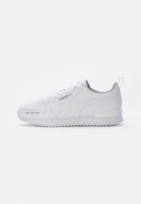 White athletic sneakers with a textured synthetic upper, flat laces, a padded collar, and a grey interior. Features rubber sole and logo accents.