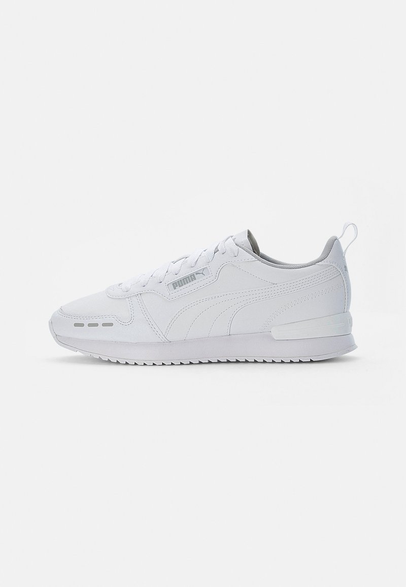 White athletic sneakers with a textured synthetic upper, flat laces, a padded collar, and a grey interior. Features rubber sole and logo accents.