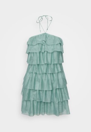 Tiered, sleeveless dress in light mint green, featuring multiple ruffled layers, a halter neck with adjustable ties, and a soft texture.
