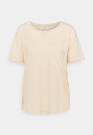 Camiseta de algodón beige con cuello redondo, mangas cortas y un bolsillo en el lado izquierdo. Textura suave y ajuste estándar.