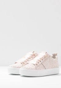 Różowe, teksturowane sneakersy z sztucznej skóry z kroko wzorem, biała gumowa podeszwa i satynowe sznurowadła. Niskoprofilowy fason z tylnim uchwytem.