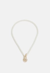 Collier en perles avec une finition lisse et blanche. Présente un pendentif doré avec un design circulaire et des accents en strass.