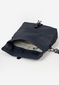 Zaino blu navy realizzato in materiale liscio, con un coperchio superiore dotato di chiusura a scatto e una tasca interna foderata in tessuto più leggero.