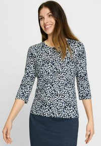 Bluse mit Blumenmuster und drei Viertelärmeln, auf einem marineblauen Hintergrund mit hellblauen Akzenten. Hergestellt aus weichem, leichtem Material.