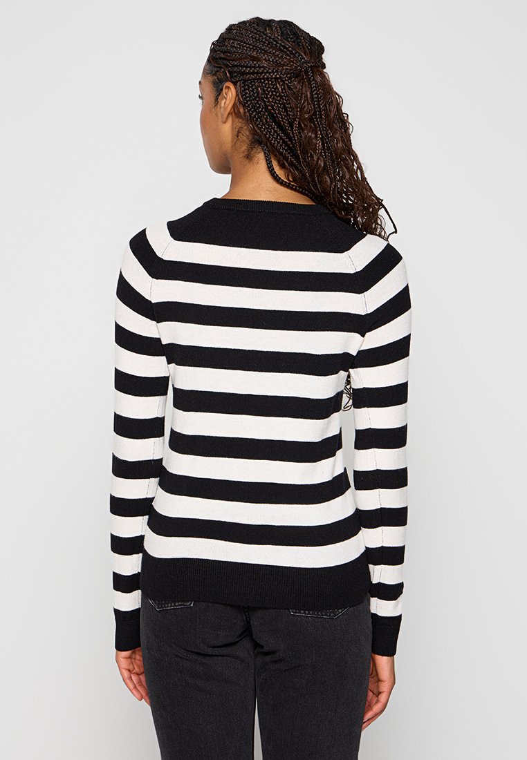 Pull en rayures noir et blanc avec un col rond. Présente des manches longues et une taille ajustée. Texture en tricot douce. Vue de dos montrée.