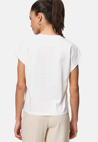 T-shirt en coton blanc avec des manches courtes roulées, coupe décontractée, texture lisse et col rond, vue de dos.
