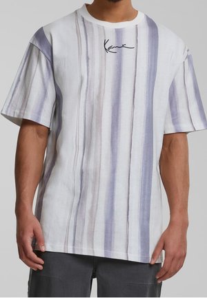 Man draagt een wit T-shirt met korte mouwen met verticale grijze en lichtpaarse strepen en een klein zwart handtekeninglogo vlak bij de halslijn.