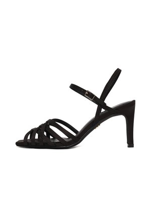 Sandalo nero con tacco alto e sottili cinturini alla caviglia con fibbia, punta aperta e tacco sottile.