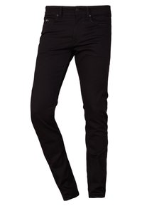 Czarne dżinsy skinny o gładkiej fakturze, pięć kieszeni, oraz srebrne akcenty z przodu. Posiadają prostą talię.