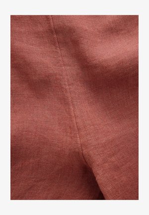 Rooste värvi lina kangas, millel on peen tekstuur ja nähtav kudumise muster, esitades sujuva ja kergelt kortsulise pinna.