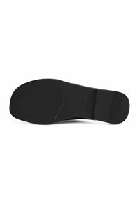 Suola di scarpa in gomma nera con una superficie texture, forma curva e punta arrotondata. Presenta un piccolo logo e un'area del tallone liscia di contrasto.