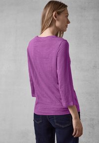 Lila Langarmshirt aus leichtem Stoff mit lässiger Passform, ausgestattet mit einem Rundhalsausschnitt und leicht ausgestelltens 3/4-Ärmeln.