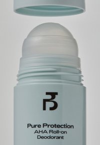 Déodorant roll-on bleu clair avec un applicateur arrondi transparent et un texte noir indiquant "Protection Pure Déodorant AHA Roll-on" sur un fond blanc.