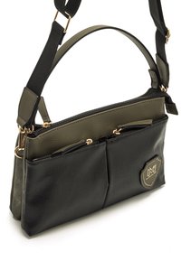 Schwarze und olivgrüne Handtasche mit strukturiertem Material, zwei Reißverschlusstaschen, goldfarbenen Beschlägen und einem Akzent-Logoanhänger. Verstellbarer Trageriemen.